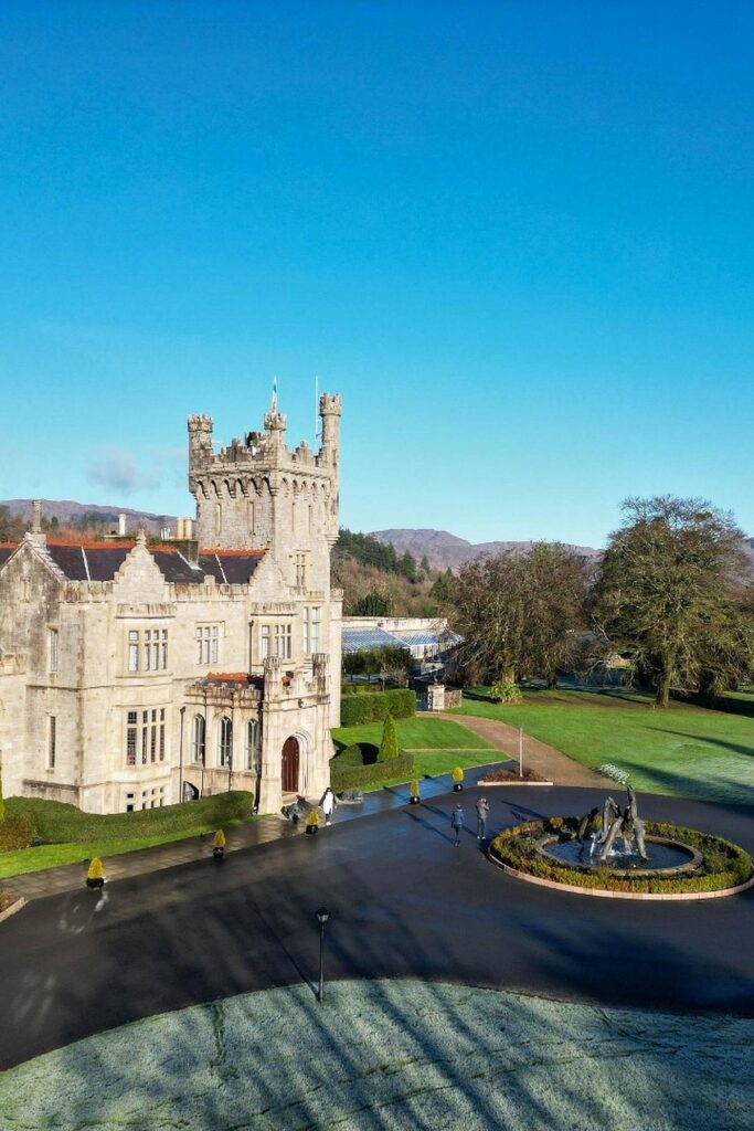 Historic stone castle surrounded by gardens and blue sky, capturing a scenic architectural marvel in natural landscape.