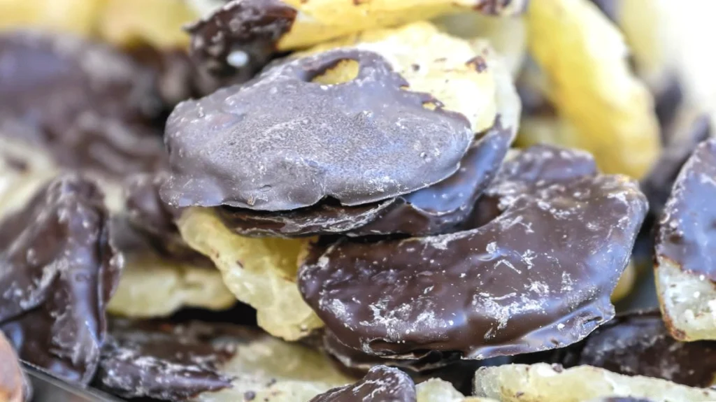 Chocolate-covered potato chips piled together, showcasing a sweet and salty snack combination.
