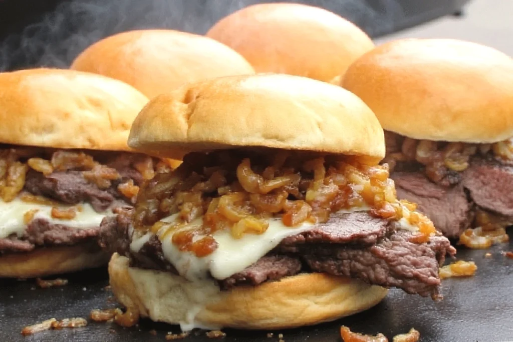 Juicy burgers topped with caramelized onions and melted cheese on a soft bun. Perfect for a delicious meal.