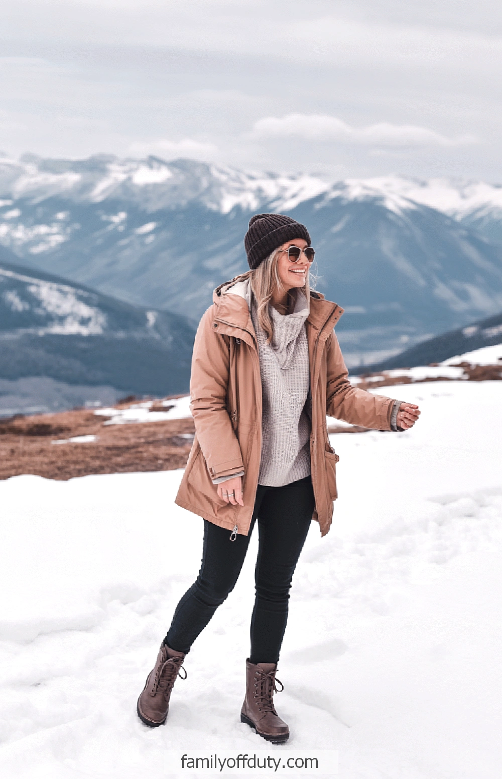 Outfits for your mountain trip. Woman in winter attire enjoying snowy mountain landscape.