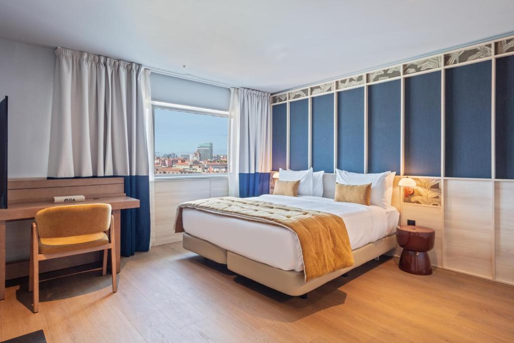 Modern hotel room with cozy double bed, city view through window, wooden floor, and stylish decor.