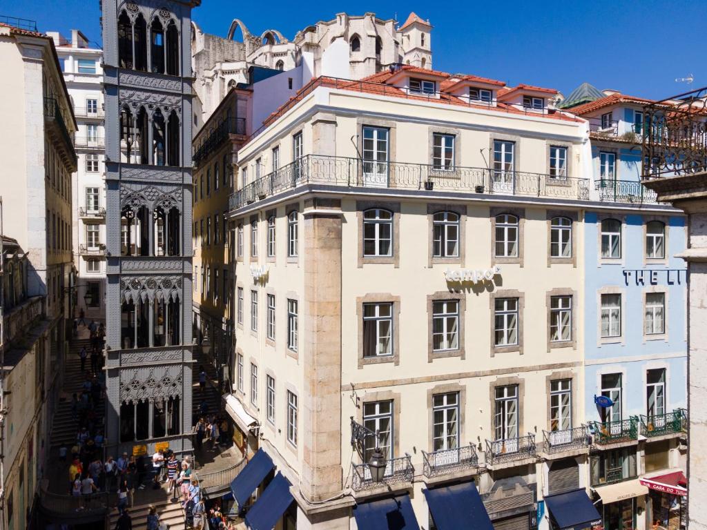 Elevador de Santa Justa in Lisbon with adjacent buildings, bustling with tourists on a sunny day.