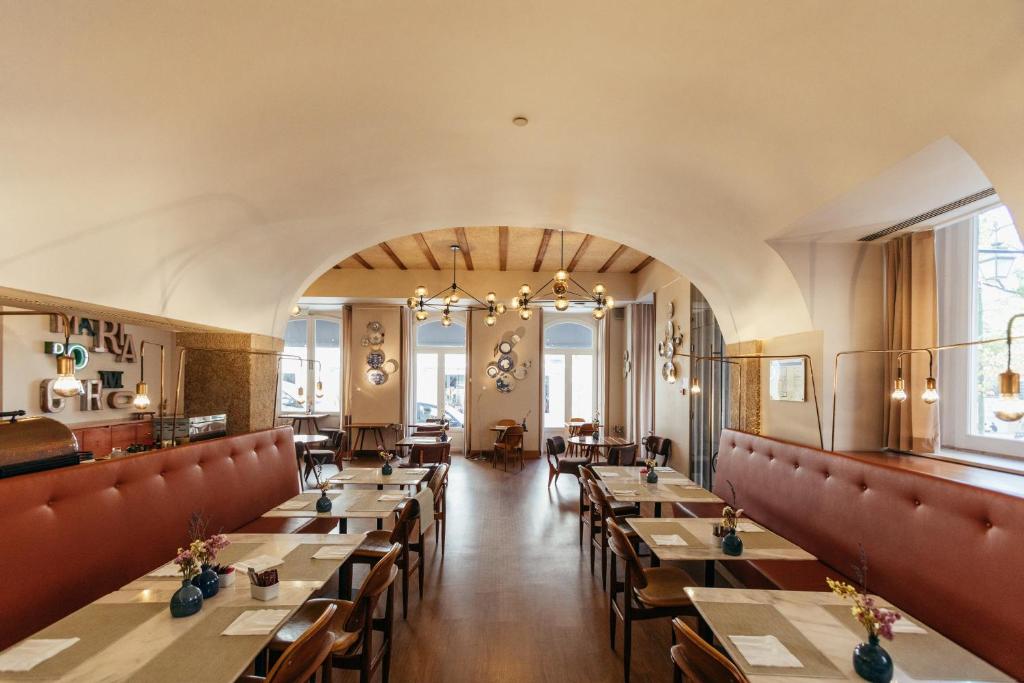 Elegant restaurant interior with wooden tables, red seating, and modern lighting, creating a cozy dining atmosphere.