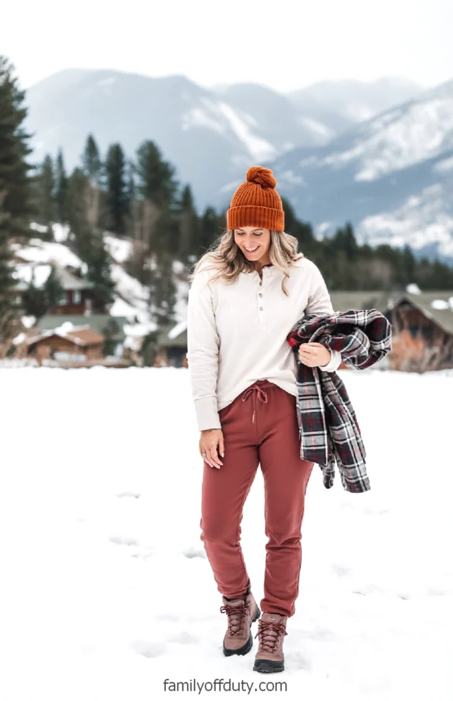 Woman in winter attire enjoying snowy mountain landscape.