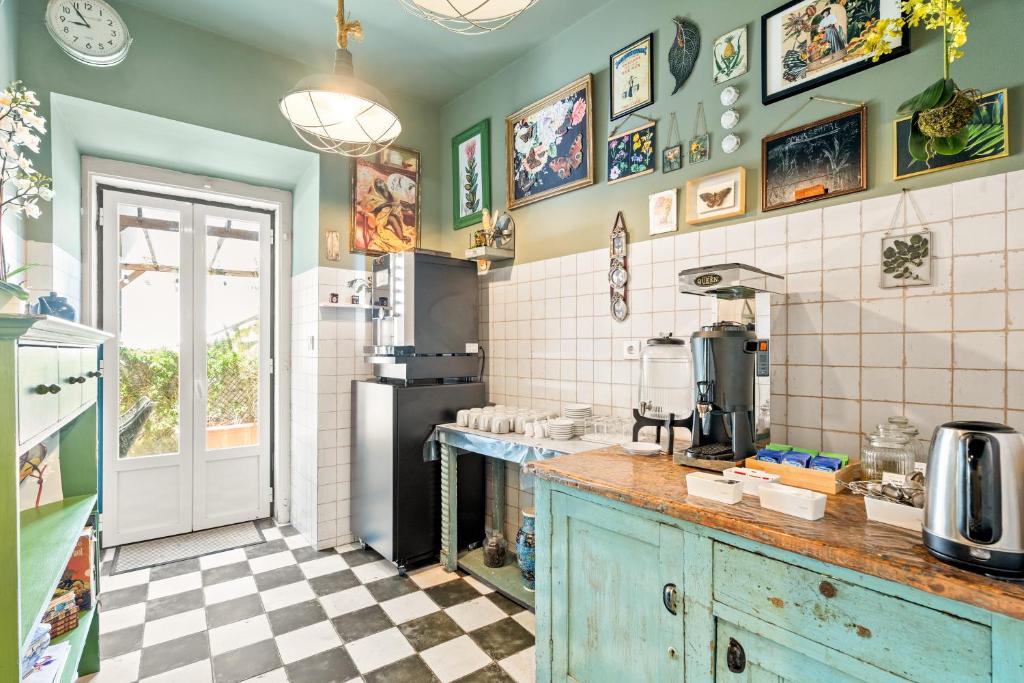 Charming vintage kitchen with coffee station, checkered floor, and art-filled walls offering a cozy, inviting ambiance.