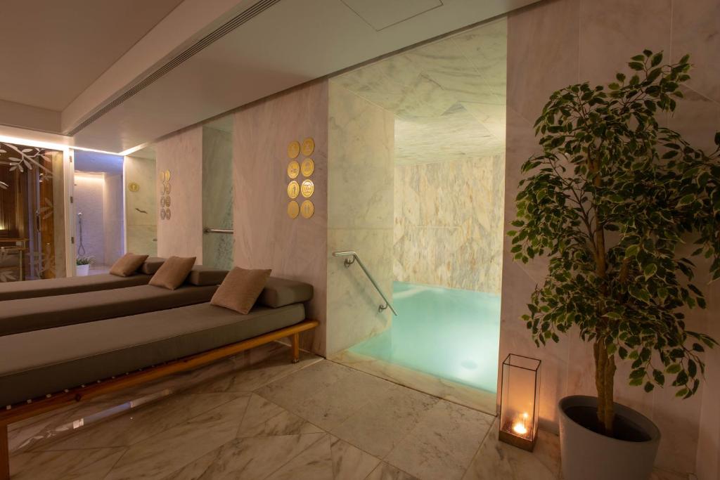 Luxurious spa with lounge chairs, warm lighting, and an inviting indoor pool for relaxation.