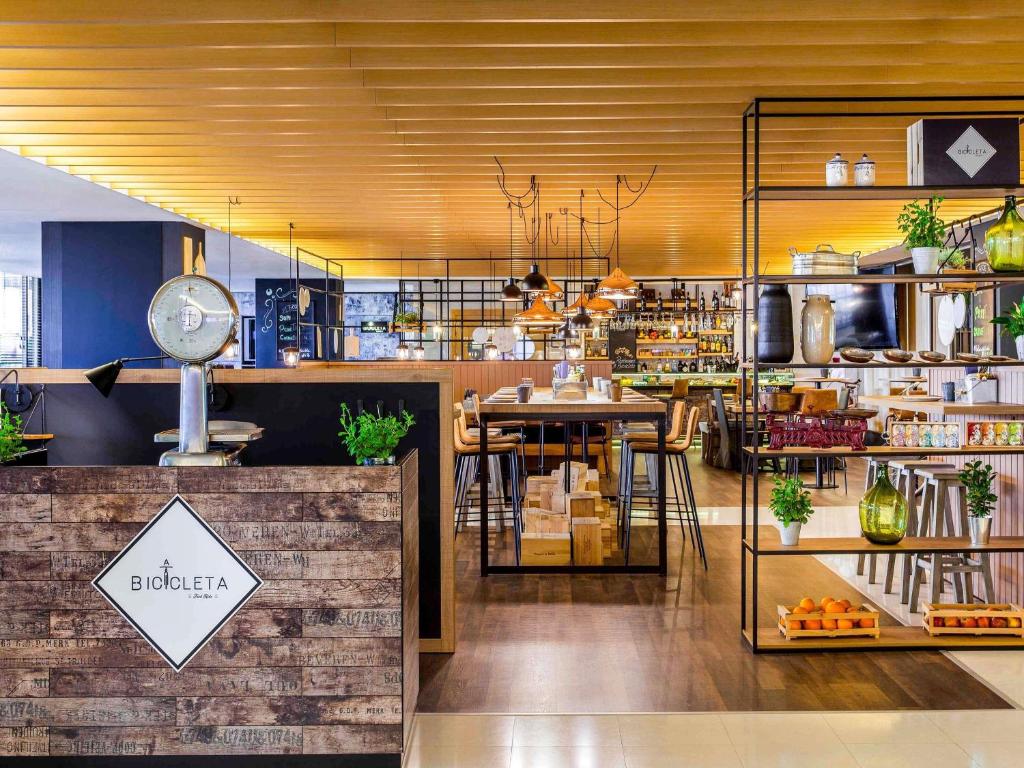 Modern cafe interior with rustic decor, wooden tables, and hanging lights, creating a cozy atmosphere.