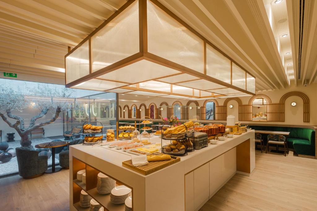 Modern buffet area with pastries and bread, open seating, and contemporary decor.