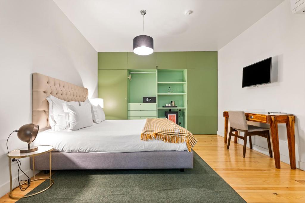 Modern hotel room with a plush bed, green wardrobe, TV, and workspace. Bright and inviting interior design.