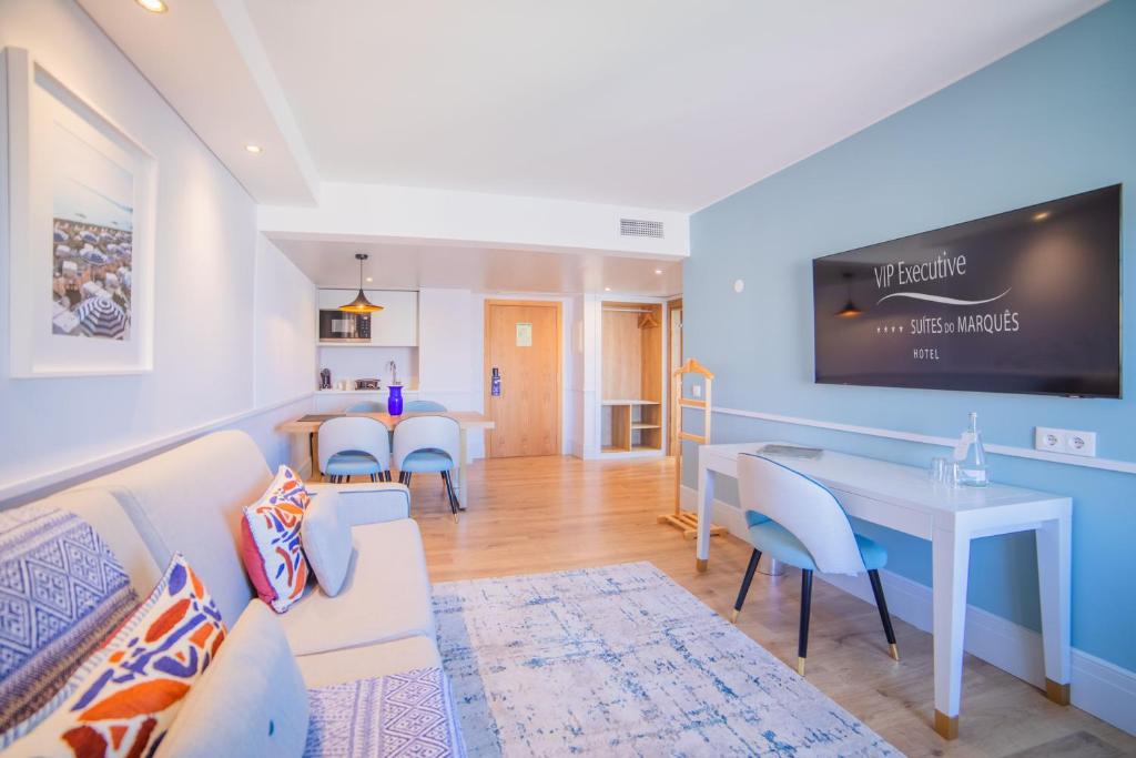 Modern hotel suite with cozy seating, work area, and dining space in bright, minimalist design.