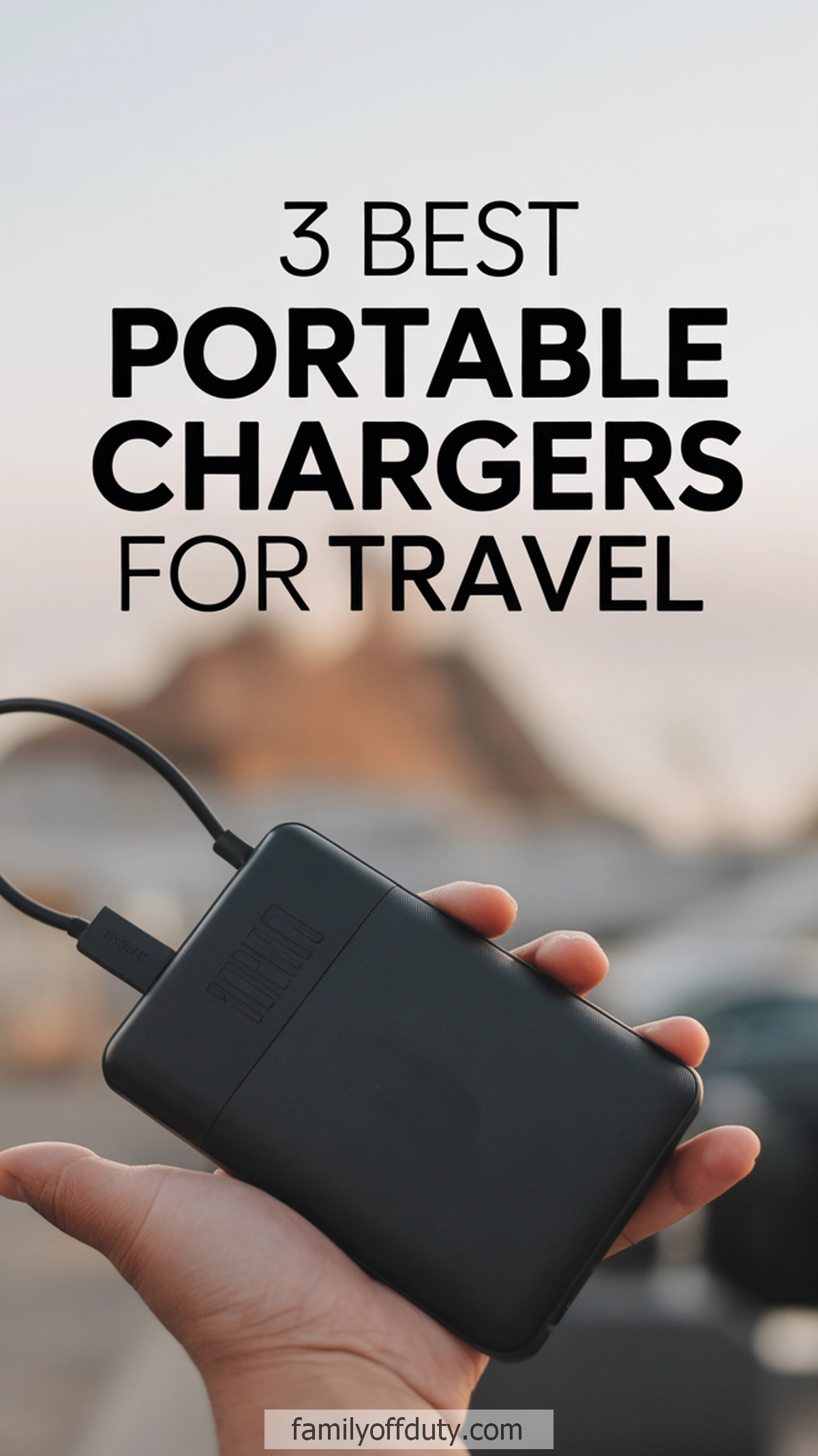 Top 3 portable chargers for travel. Hand holding a black power bank against a blurred outdoor background.