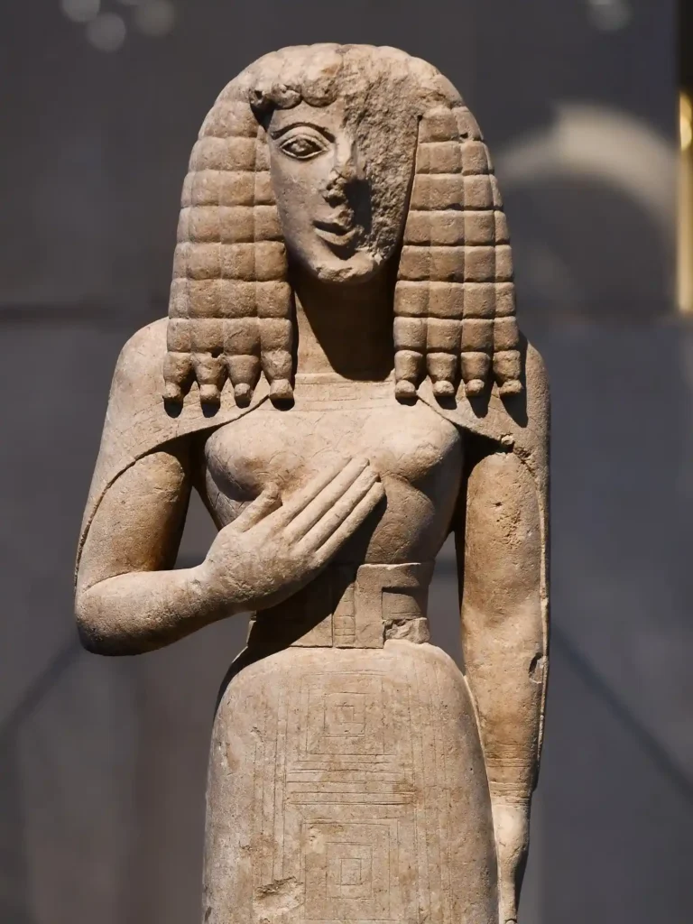 Ancient Egyptian limestone statue with intricate braided hair, showcasing detailed carvings and a serene expression.