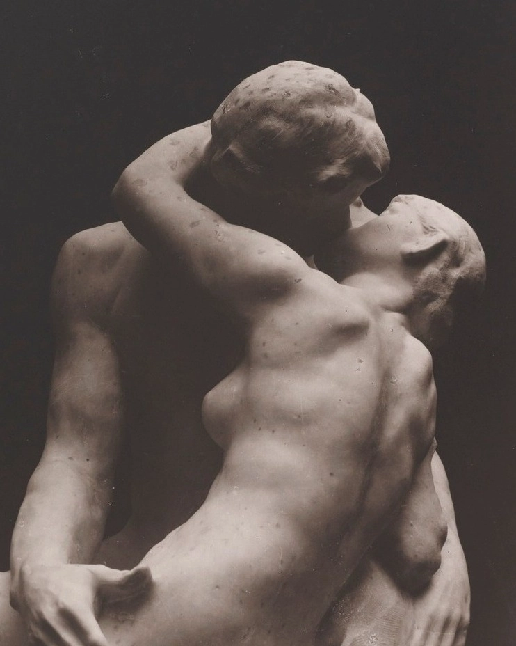 Romantic marble sculpture of two figures embracing and kissing passionately, showcasing intimacy and love.