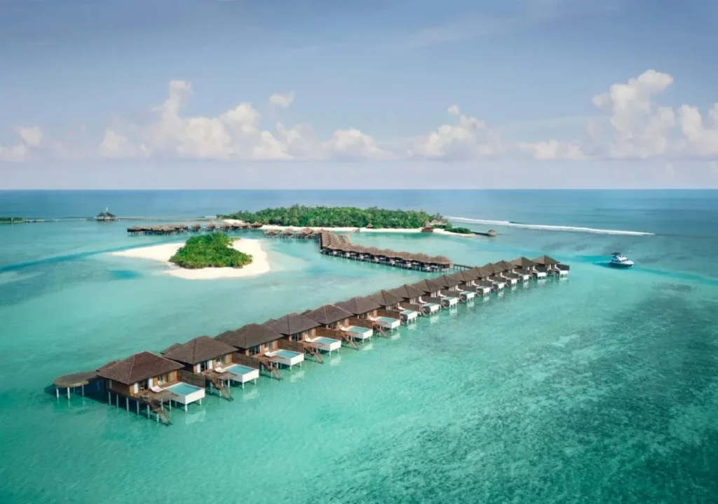 Tropical overwater bungalows with a turquoise lagoon and lush island backdrop, perfect for a serene getaway.