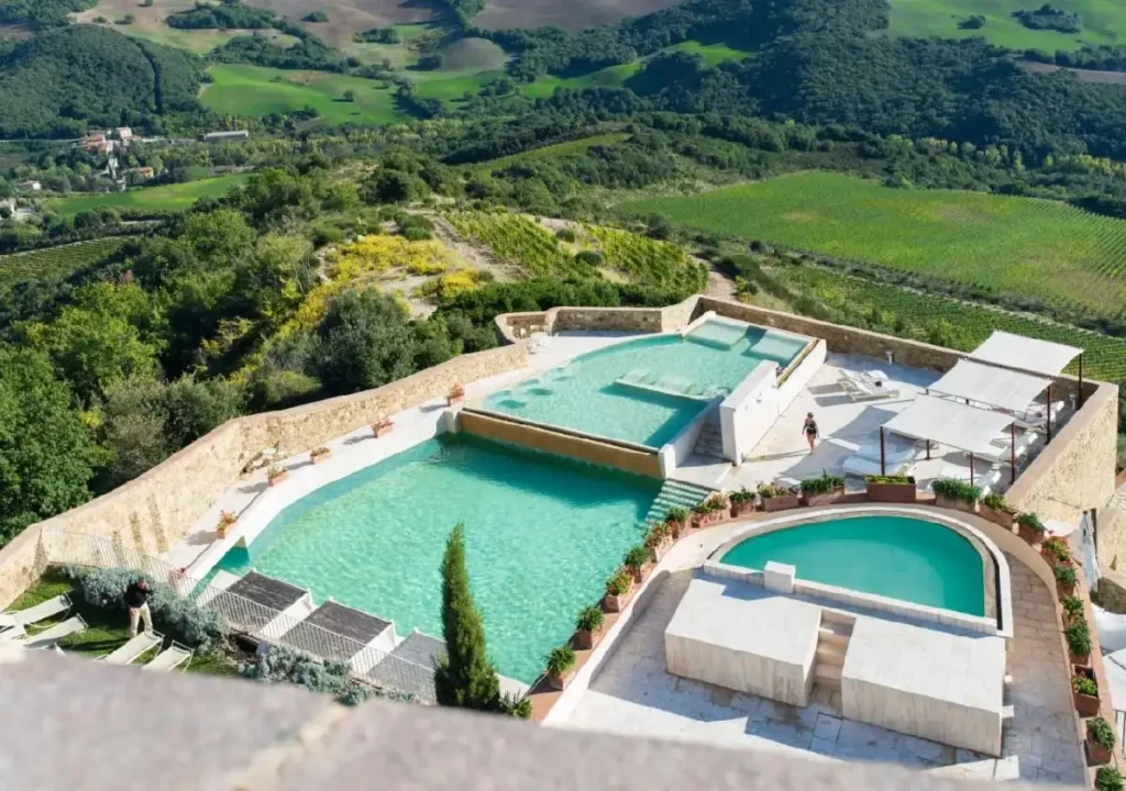 Beautiful panoramic view of modern pools surrounded by lush greenery and hills, ideal for relaxation and leisure.