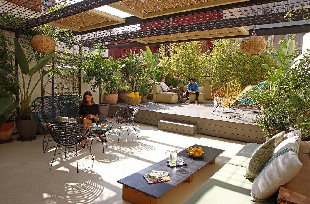 Cozy rooftop garden with lush plants, seating areas, and people relaxing for a perfect outdoor escape.