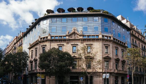 Modern architecture blends with historical elements in this striking building in Barcelona under a clear blue sky.