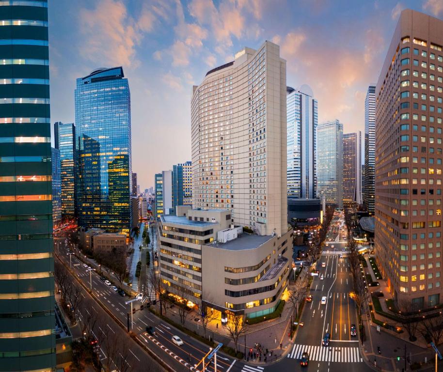 Panoramic view of a bustling cityscape with skyscrapers, streets, and vibrant twilight skies.
