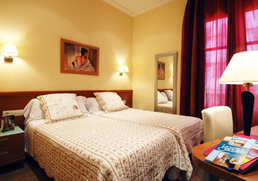 Cozy hotel room featuring twin beds, warm lighting, and elegant decor, perfect for a relaxing stay.