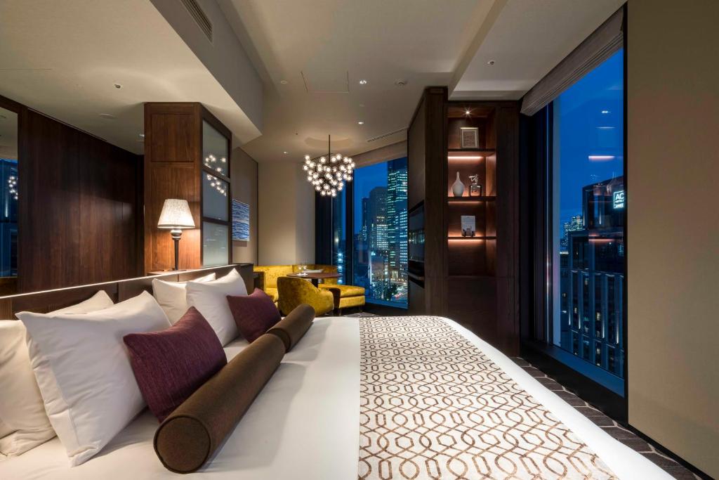 Luxurious hotel bedroom with city skyline views, modern decor, and ambient lighting creating a cozy atmosphere.