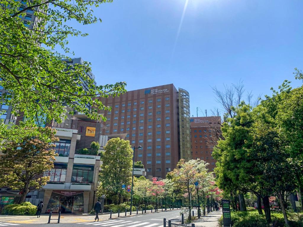 Modern city landscape featuring trees, buildings, and a clear blue sky in Tokyo, Japan on a sunny day.
