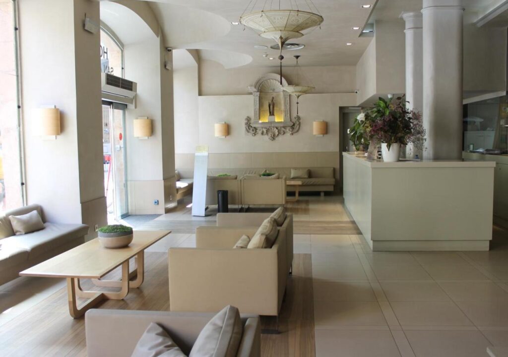 Modern hotel lobby featuring minimalist design, cozy seating, and elegant decor, inviting guests to unwind.