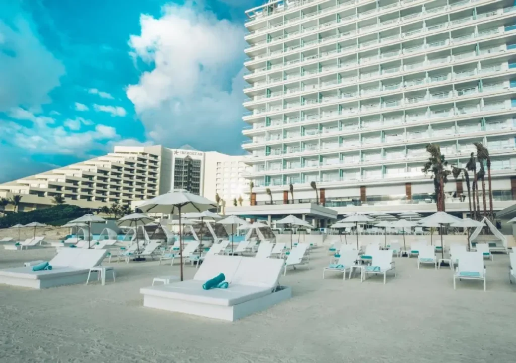 Luxurious beach resort with white loungers and umbrellas, offering stunning ocean views and relaxation opportunities.