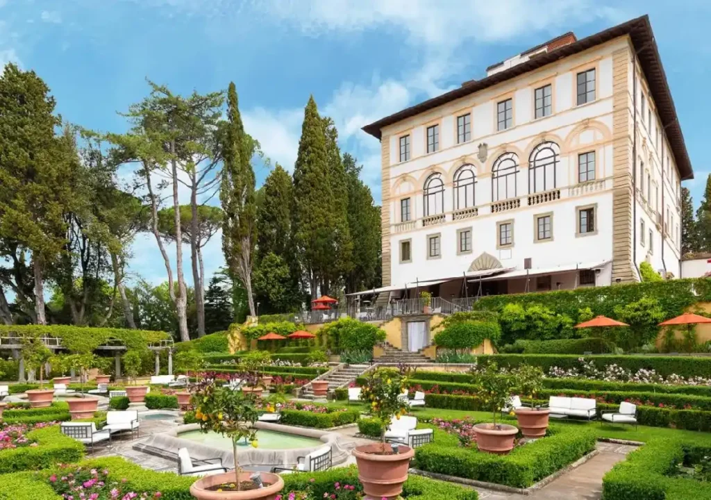 Beautiful historic villa surrounded by lush gardens and vibrant flowers, perfect for relaxation and scenic views.