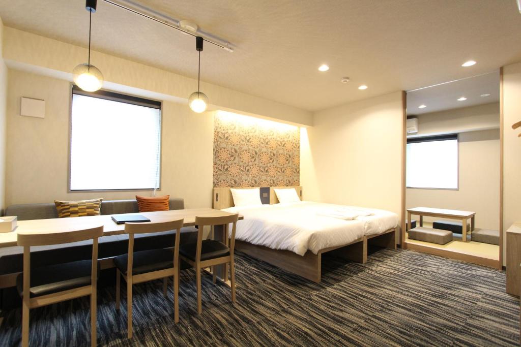 Spacious hotel room with a double bed, dining area, and modern decor, perfect for a relaxing stay.