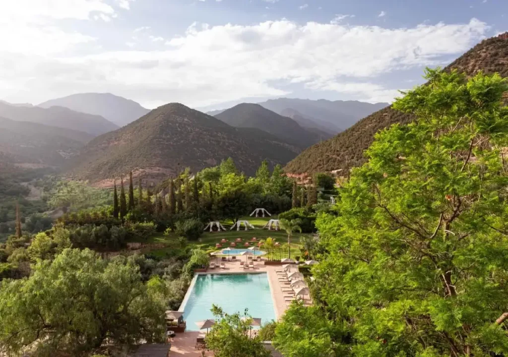 Serene mountain resort featuring a pool and lush gardens, perfect for relaxation amid stunning natural scenery.