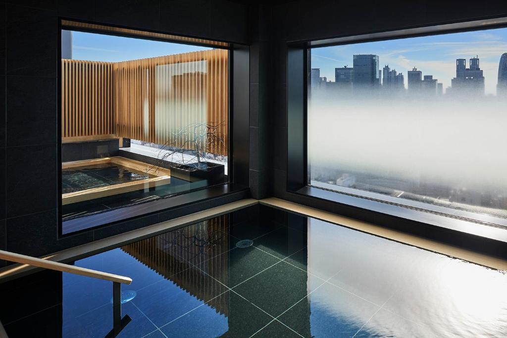 Luxurious indoor spa with panoramic city views and a tranquil water feature, perfect for relaxation and rejuvenation.