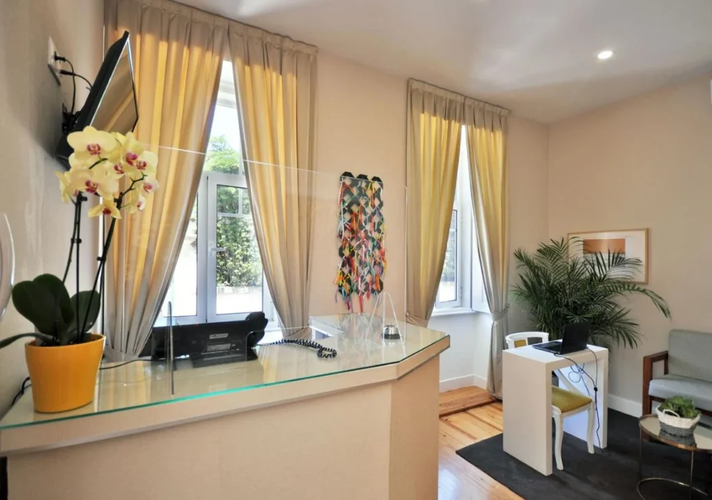 Stylish reception area with natural light, plants, and modern decor, creating a welcoming ambiance.