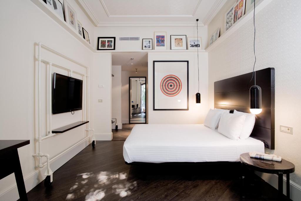 Modern hotel room featuring a minimalist design, wall art, and cozy bedding, perfect for relaxation and comfort.