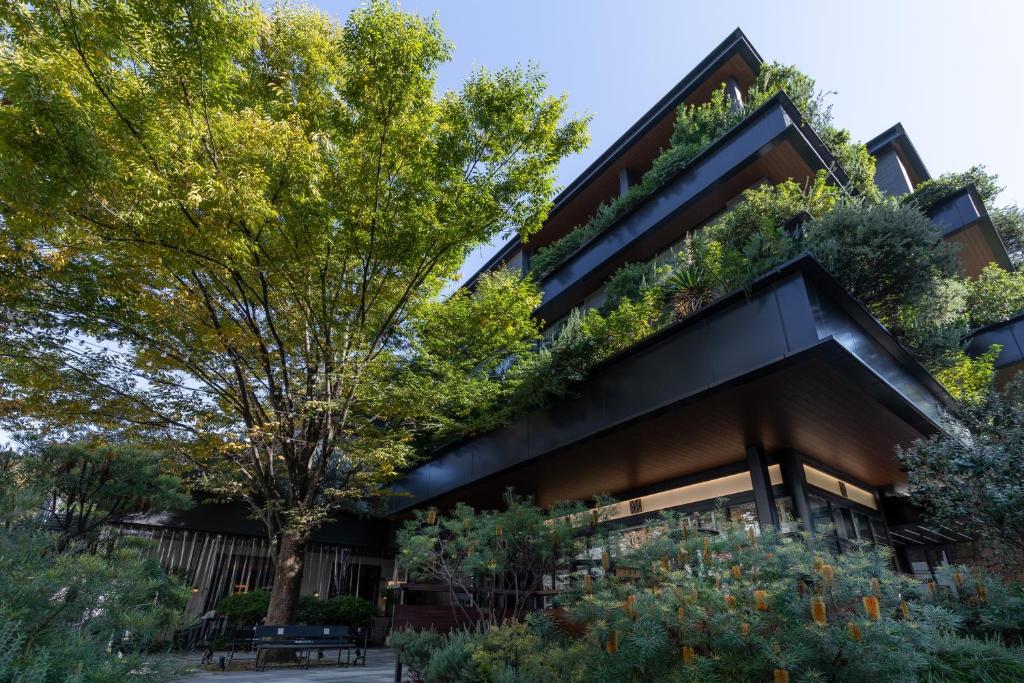 Modern architecture blends with lush greenery in a sleek multi-story building surrounded by vibrant trees.