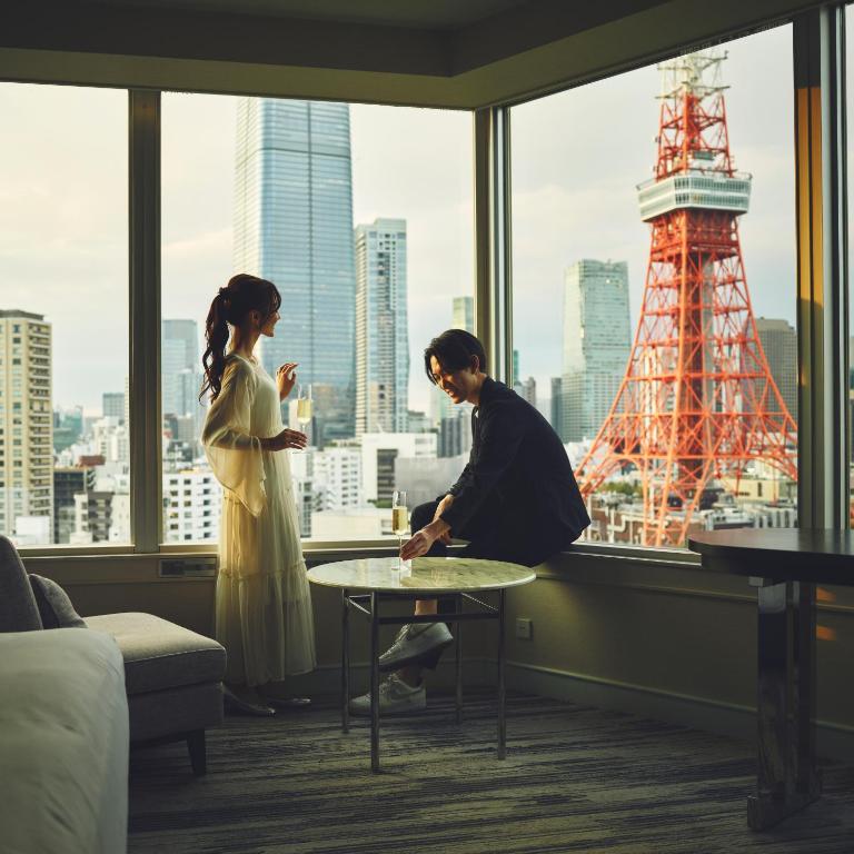 Couple enjoying a moment together in a modern hotel room with Tokyo Tower in the background.