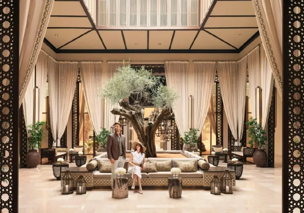 Elegant hotel lobby featuring a central tree, lavish seating, and inviting decor, perfect for relaxation and luxury.