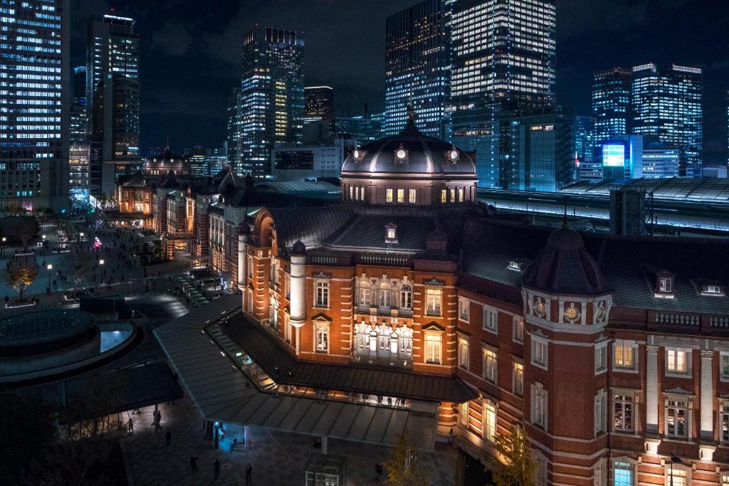 Night view of Tokyo Station, showcasing its stunning architecture amidst vibrant city lights and modern skyscrapers.