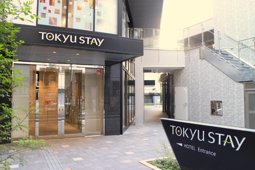 Entrance of Tokyu Stay hotel featuring modern design and welcoming atmosphere in an urban setting.