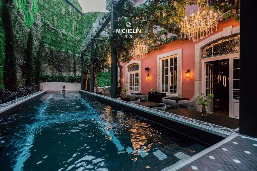 Luxurious outdoor pool area adorned with chandeliers and lush greenery, perfect for a Michelin-starred dining experience.