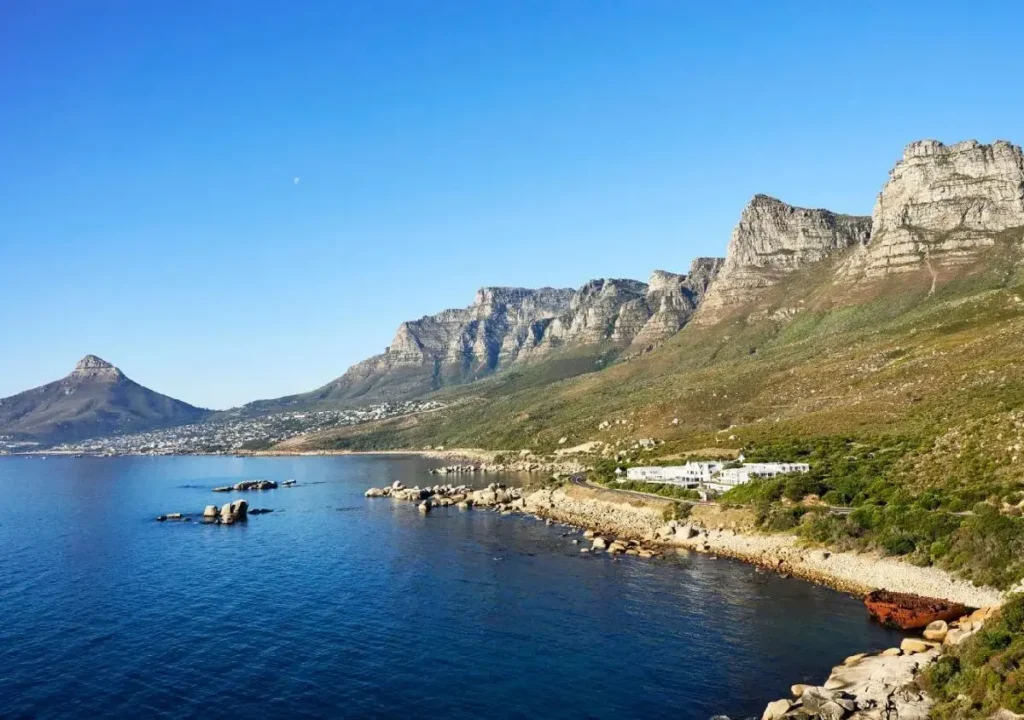 Stunning coastal view of mountains and clear blue water, capturing the natural beauty of South Africa's landscape.