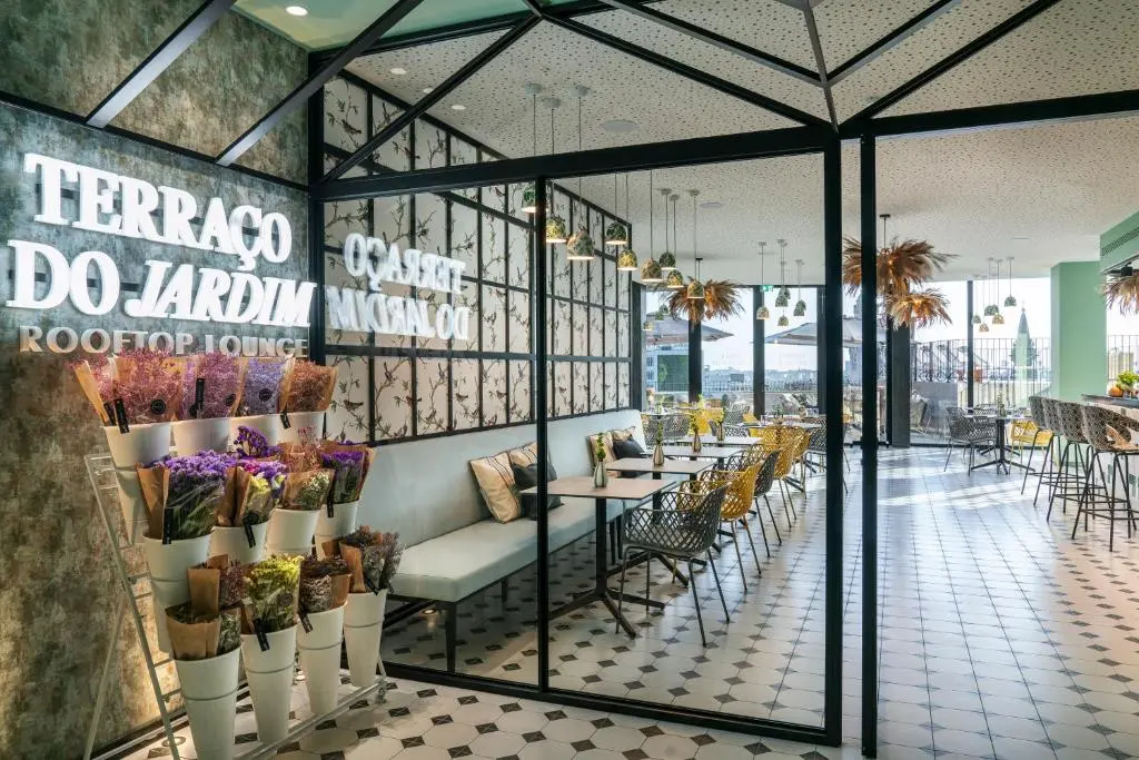 Modern rooftop lounge Terraço do Jardim featuring elegant decor, greenery, and inviting seating for dining.