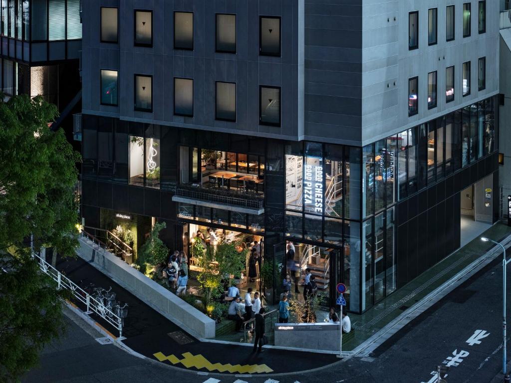 Modern pizza restaurant exterior at night, showcasing vibrant outdoor seating and welcoming ambiance.