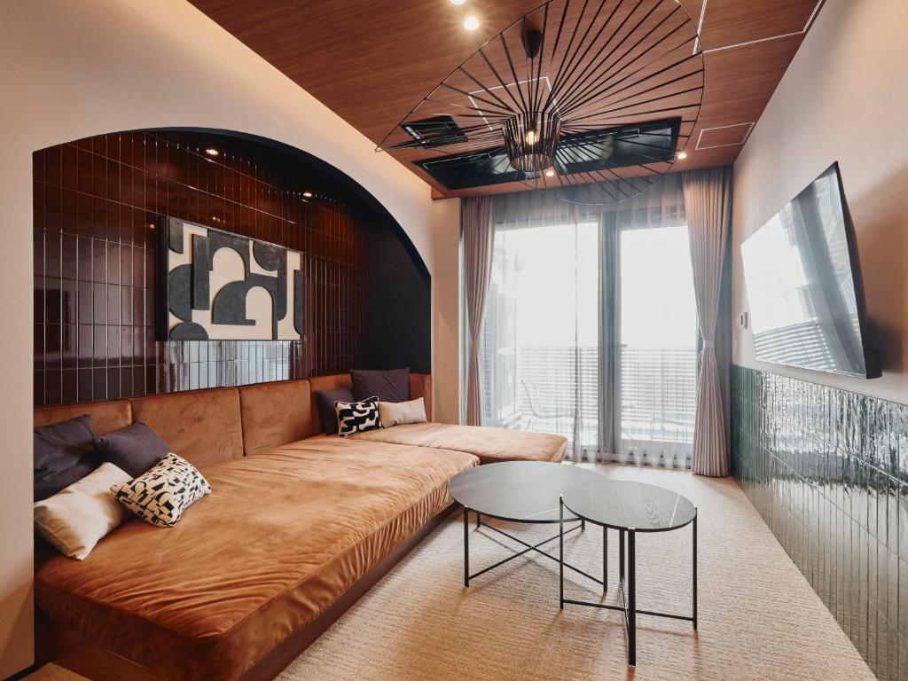 Modern living room with a cozy sofa, stylish decor, and natural light from large windows. Perfect for relaxation.