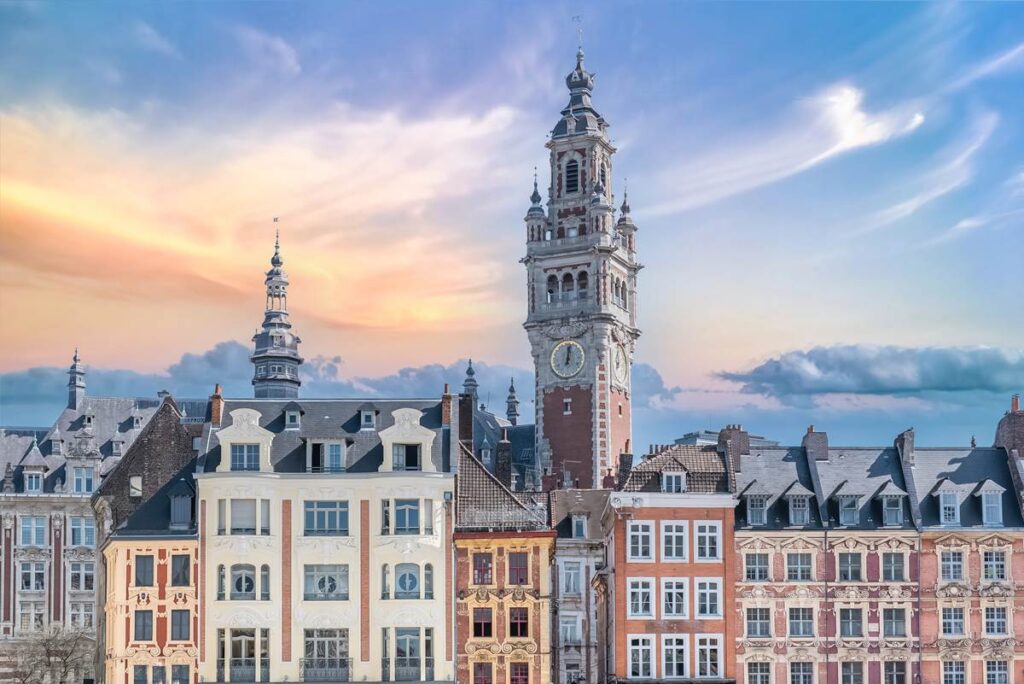 Scenic view of Lille's historic architecture and Belfry of Lille at sunset, under a colorful sky.