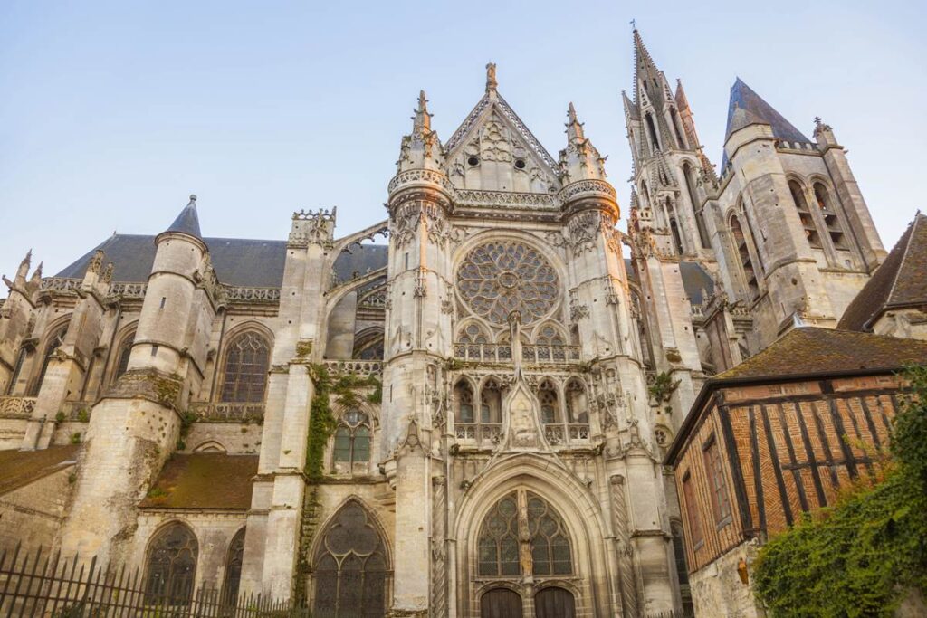 Gothic cathedral facade with intricate rose window under a clear sky, showcasing stunning architecture.