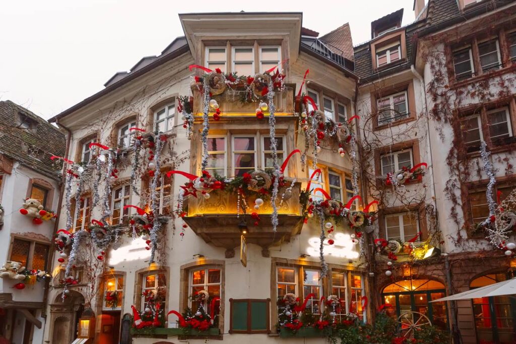Charming building with festive Christmas decorations, featuring red ribbons, lights, and holiday wreaths.