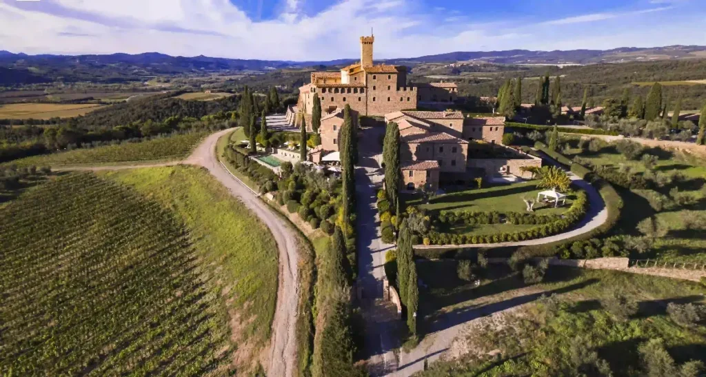 Aerial view of a stunning Tuscan villa surrounded by lush vineyards and picturesque landscapes. Ideal for getaways.