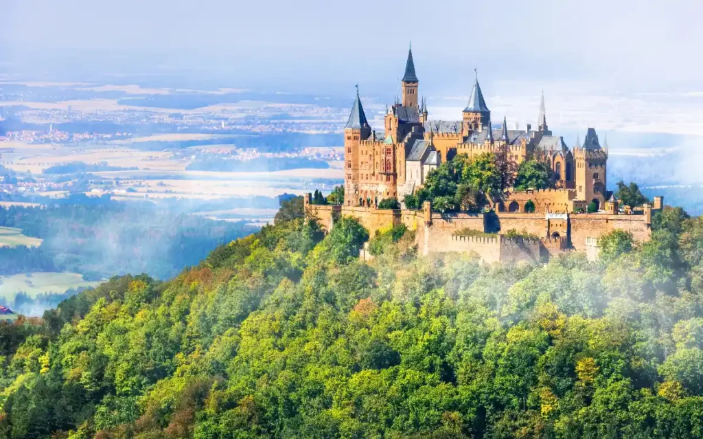 Majestic castle perched on a hill, surrounded by lush forests and scenic landscapes under a bright sky.