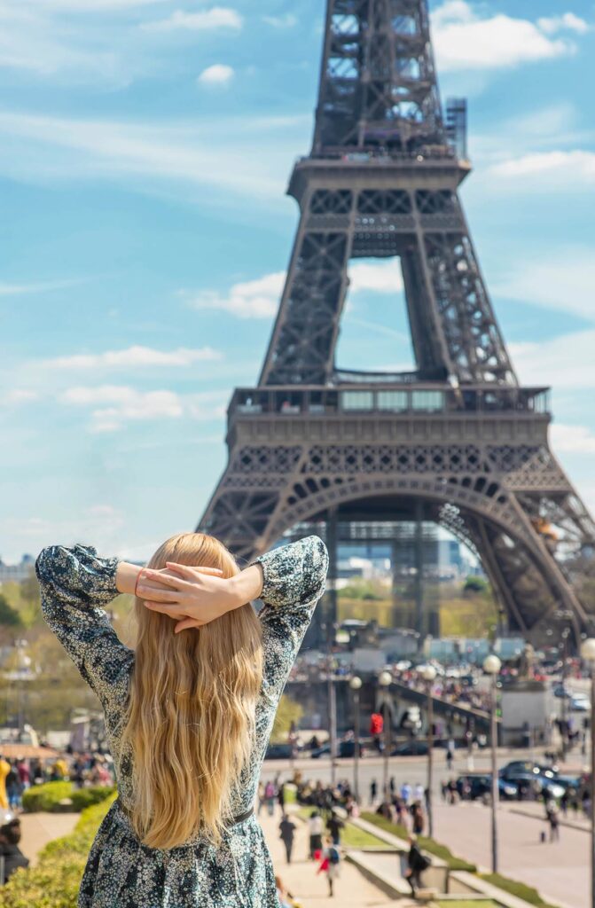 Woman enjoying Eiffel Tower view on sunny day in Paris.